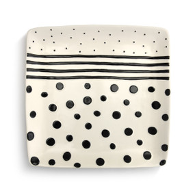 An ivory platter with black polka dots and stripes.