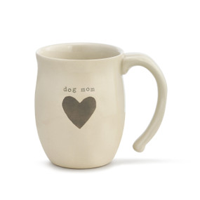 An ivory coffee mug with "dog mom" engraved above a brown heart.