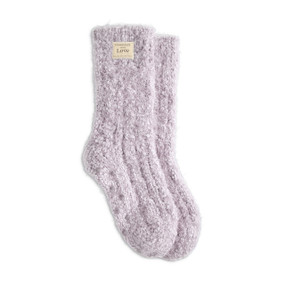 A pair of light purple fuzzy socks with a small cream Giving Collection fabric tag attached.