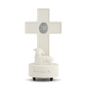 A ceramic cross and lamb medallion musical cross that reads "Jesus Loves Me".