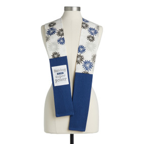 A cream floral fabric kitchen boa with blue towel ends and a white fabric patch that says "Baking is my Super Power" displayed on a mannequin.