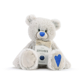 A fluffy white plush bear with a dark blue nose, dark blue heart, and a white product tag that reads "Clever September".