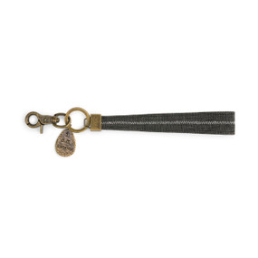 A black burlap wrist strap with a gold ring, a gold hook, and a gold tag that reads "I am enough".