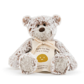 A smiling plush white and brown bear with a sentimental message.