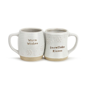 A pair of ivory and beige coffee mugs that read "Warm Wishes" and "Snowflake Kisses".