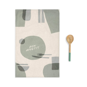 A beige kitchen towel with green and blue shapes with a matching wooden spoon.