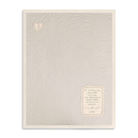 A soft beige baby blanket with thin white stripes, a hear patch, a sentimental message patch, and a beige lining.
