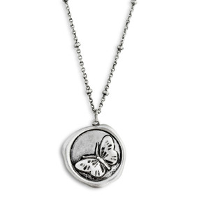 A close up image of a circular pendant with a butterfly on a dainty silver necklace.