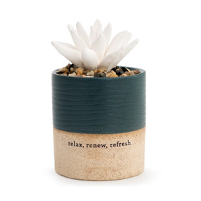A small, speckle textured, tan and dark teal vase, that reads relax, renew, refresh.", and is filled with an assortment of small rocks, and a white succulent oil diffuser."