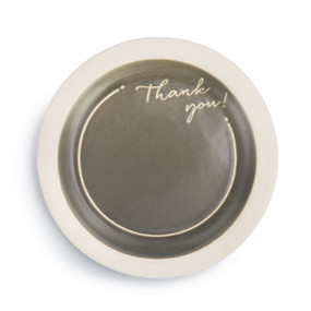 A small circular gray and cream celebration plate with "Thank you!" engraved in a cursive font.