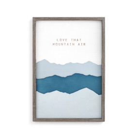 A gray frame enclosing a blue mountain wall art piece that reads "love that mountain air".