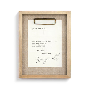 A white letter with black handwriting pinned into a wooden frame with burlap backing.