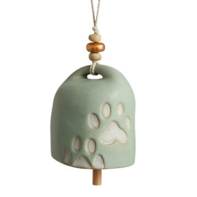 A light green Inspired Bell" with a two cream paw prints, a twine rope, and gold and wooden beads."