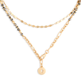 A gold wrap necklace/bracelet with various gold and silver beads, and a circular gold pendant with a cross shape cutout.