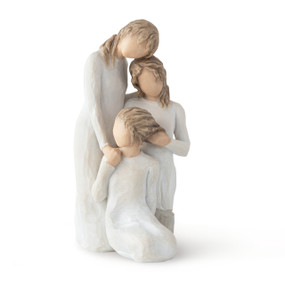 Front view, figurine of three females in cream dresses: one standing with arm around kneeling female, and holding hand of seated female