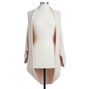 A light, long sleeved, soft pink wrap placed on a white and black mannequin.