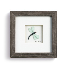 A pebble scene of a butterfly, enclosed in a dark wooden frame.