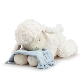 A plush, white laying lamb with a simple blue heart on its paw. Holding a soft blue blanket with a silver cross.