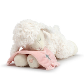 A plush, white laying lamb with a simple pink heart on its paw. Holding a soft pink blanket with a silver cross.