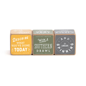 A set of three wood dice placed next to each other that create a directive of something funny to do. The dice are dark yellow, green and gray with white writing.