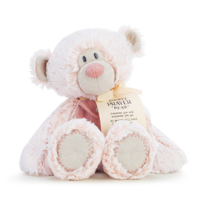 A pale pink plush bear with a dark pink corduroy pocket and wearing a cream fabric tag.