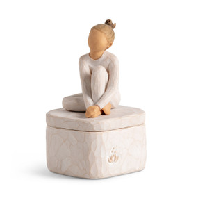 Front view: cream square resin box with lid, 3-d carving of girl in cream leotard sitting atop lid