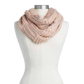 A blush colored infinity scarf displayed on a white mannequin.