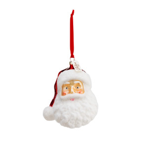 A blown glass ornament of a Santa head. With a large white beard and Santa hat. With a red ribbon string.