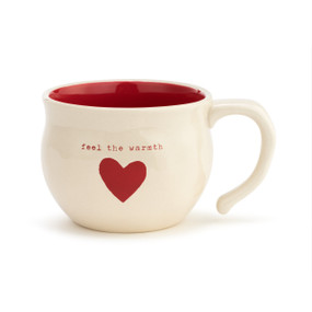 A large cream, ceramic, soup bowl mug with a red inner lining, a red heart, and reads "feel the warmth" in red typewriter font.