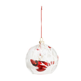 A glass ornament with a tree pattern in white, and filled with a red glitter cardinal.