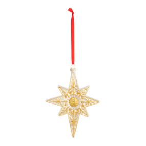 A front facing view of a blown glass white and gold Star of Bethlehem, with a red ribbon string.
