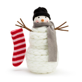 A soft white knit snowman figure, with a wool body, a black stocking hat, a brown scarf, and a striped stocking.