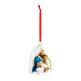 A right facing view of a white blown glass ornament of a nativity scene. With a red velvet string.