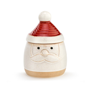 A Santa themed candy dish, with the face and a tan base as the jar, and a textured red and white hat as the lid, placed on top of the jar.