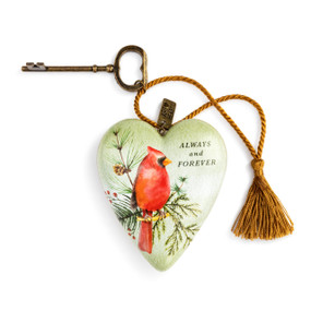 A textured green and white Art heart with a painting of a red cardinal on a pine branch, and reads "always and forever". With a bronze key and gold tassel.
