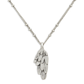 Close up view of the pendant on a silver necklace with a silver feathered wing shaped pendant.
