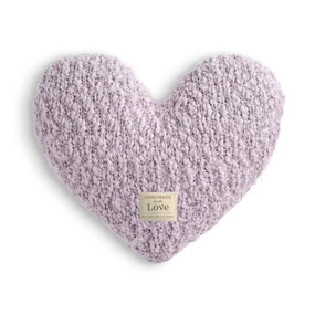 A light purple heart shaped Giving Collection pillow with a small cream fabric Giving Collection tag attached.