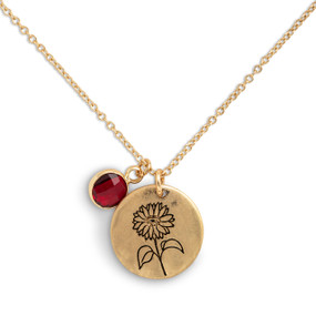 Detail view of the charms on a delicate gold necklace with a round gold charm with the birth flower for July and a separate birthstone.