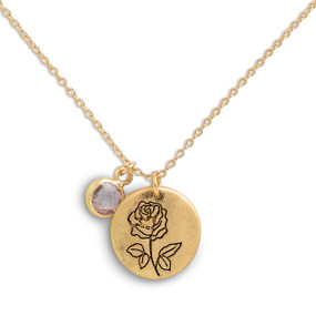 Detail view of the charms on a delicate gold necklace with a round gold charm with the birth flower for June and a separate birthstone.