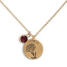 Detail view of the charms on a delicate gold necklace with a round gold charm with the birth flower for January and a separate birthstone.