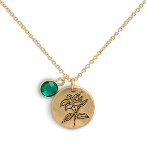 Detail view of the charms on a delicate gold necklace with a round gold charm with the birth flower for May and a separate birthstone.