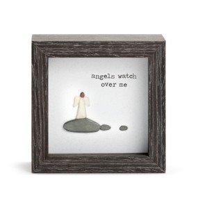A square dark wood shadow box with a stone image of an angel standing on a rock that says "angels watch over me".