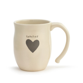 Front view of a cream handled ceramic mug that says "teacher" above a dark gray heart.