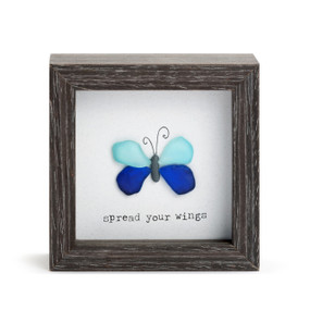 A square dark wood shadow box with a blue stone butterfly that says "spread your wings".
