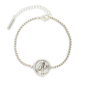 A silver metal bracelet that has a round metal charm with two birds a tree.
