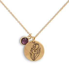 Detail view of the charms on a delicate gold necklace with a round gold charm with the birth flower for February and a separate birthstone.