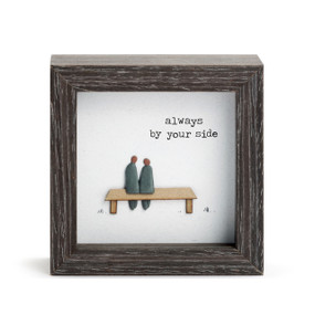 A square dark wood shadow box with a stone couple sitting on a bench that says "always by your side".