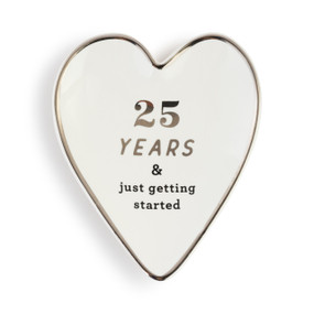 Heart shaped ceramic dish with a silver rim. The interior is white and says "25 Years & just getting started" in silver.