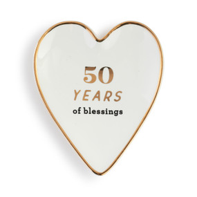 Heart shaped ceramic dish with a gold rim. The interior is white and says "50 Years of blessings".