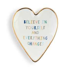 Heart shaped ceramic dish with a gold rim. The interior is white and says "Believe in Yourself and Everything Changes".